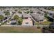 Beautiful aerial view of a backyard featuring a brick paver patio, lounge chairs, and meticulous landscaping at 1802 Dalton Dr, The Villages, FL 32162