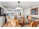 Dining area with glass-top table, upholstered chairs, and white kitchen at 1802 Dalton Dr, The Villages, FL 32162