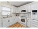 Bright kitchen featuring white cabinets, stainless steel appliances, and stylish countertops at 1802 Dalton Dr, The Villages, FL 32162