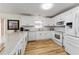 Bright kitchen featuring white cabinets, stainless steel appliances, and stylish countertops at 1802 Dalton Dr, The Villages, FL 32162