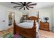 Bedroom featuring wood floors, a four-poster bed, and a view into the bathroom at 1802 Dalton Dr, The Villages, FL 32162