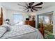 Bedroom with wood floors, a ceiling fan, a dresser, and a view into the patio at 1802 Dalton Dr, The Villages, FL 32162