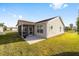 View of the home's back, showcasing a screened-in patio and well-maintained lawn at 2046 Dalecroft Trl, The Villages, FL 32162