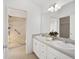 Bathroom featuring a dual-sink vanity and walk-in shower with decorative tile at 2046 Dalecroft Trl, The Villages, FL 32162