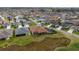 Wide aerial view of the property showing the backyard, screened-in porch, and surrounding neighborhood landscape at 2050 Biller Cir, The Villages, FL 32163