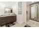 Bathroom featuring tiled shower, stone floor, granite countertop, and decorative mirror at 2050 Biller Cir, The Villages, FL 32163