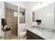 Modern bathroom with granite countertop, glass block, tiled shower, and pebble floor at 2050 Biller Cir, The Villages, FL 32163