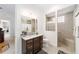 Bathroom featuring a tiled shower, pebble floor, granite countertops, and wood cabinetry at 2050 Biller Cir, The Villages, FL 32163