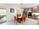 Dining area with modern lighting, a wooden table set, and outdoor access overlooking green landscape at 2050 Biller Cir, The Villages, FL 32163