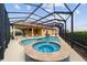 Sparkling swimming pool and spa surrounded by a screened enclosure and comfortable lounge furniture at 2050 Biller Cir, The Villages, FL 32163