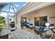 Covered patio featuring tile floor, fan, and comfortable wicker seating with blue cushions and a view at 2114 Gerardo Ave, The Villages, FL 32159