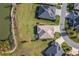 Aerial view of home with a large backyard, screened lanai, and nearby pond at 2124 Biller Cir, The Villages, FL 32163