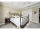 Cozy bedroom featuring a metal frame bed, nightstands, and neutral walls with white trim and a fan at 2124 Biller Cir, The Villages, FL 32163