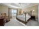 Comfortable bedroom showcasing a metal frame bed, neutral walls, carpet, and a large window for natural light at 2124 Biller Cir, The Villages, FL 32163