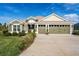 Charming single-story home with a well-manicured lawn and a three-car garage at 2124 Biller Cir, The Villages, FL 32163