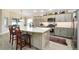 Bright kitchen featuring an island, granite countertops, and modern appliances at 2124 Biller Cir, The Villages, FL 32163