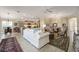 Spacious living room open to the kitchen and dining area, featuring stylish decor and wood-look tile flooring at 2124 Biller Cir, The Villages, FL 32163