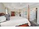 Comfortable main bedroom highlighting a decorative ceiling, four-poster bed, and access to ensuite bathroom at 2124 Biller Cir, The Villages, FL 32163