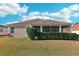 Exterior view of home featuring well-maintained lawn and mature landscaping at 2311 Bramble Ter, The Villages, FL 32162