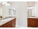 Double sink bathroom vanity with granite countertop and two decorative lights at 2311 Bramble Ter, The Villages, FL 32162