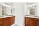 Bathroom featuring double sinks with granite countertops and wood cabinetry at 2311 Bramble Ter, The Villages, FL 32162