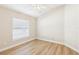 Bedroom with wood-look flooring, light walls, and a ceiling fan at 2311 Bramble Ter, The Villages, FL 32162