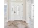 Bright foyer with tile flooring, showcasing a front door with decorative glass inserts and sidelights at 2311 Bramble Ter, The Villages, FL 32162