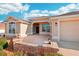 Inviting front entrance with a covered porch, decorative brick accents, and a two-car garage at 2311 Bramble Ter, The Villages, FL 32162