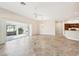 Bright, open-concept living room featuring tile floors, a ceiling fan, and access to the kitchen and lanai at 2311 Bramble Ter, The Villages, FL 32162