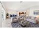 Bright and airy living room with a large rug, couches, and kitchen in background at 2311 Bramble Ter, The Villages, FL 32162