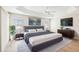 A staged main bedroom has a tray ceiling, ceiling fan, and decorative bedside lamps at 2311 Bramble Ter, The Villages, FL 32162