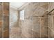 Shower featuring lovely tile work, a built-in seat, and a glass block window at 2311 Bramble Ter, The Villages, FL 32162