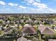 Expansive aerial view showcasing the neighborhood's well-spaced homes under a bright, partly cloudy sky at 2360 Unity Ter, The Villages, FL 32162