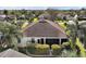 High angle aerial view features the rear of a home with mature landscaping and a screened in back porch at 2360 Unity Ter, The Villages, FL 32162