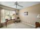 Neutral bedroom with a ceiling fan and natural light from a window that is nicely staged with furniture and decor at 2360 Unity Ter, The Villages, FL 32162