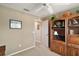 A tan bedroom featuring a ceiling fan and a built-in wooden entertainment center perfect for storage and media at 2360 Unity Ter, The Villages, FL 32162