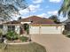 Charming single-story home with a well-manicured lawn and a paved driveway leading to a spacious three-car garage at 2360 Unity Ter, The Villages, FL 32162