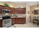 Well-equipped kitchen featuring dark wood cabinetry, granite countertops, and stainless steel appliances and breakfast nook at 2360 Unity Ter, The Villages, FL 32162