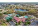 Aerial view showcases tennis courts, pool, clubhouse, parking, and surrounding neighborhood at 26315 Newcombe Cir, Leesburg, FL 34748