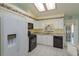 Bright kitchen with white cabinetry, black appliances, and a skylight providing natural light at 26315 Newcombe Cir, Leesburg, FL 34748