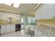 Sunlit kitchen featuring white cabinets, granite countertops, an island, and an exterior door at 26315 Newcombe Cir, Leesburg, FL 34748