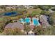 Aerial view of a stunning community pool area featuring multiple pools, lounge seating, and lush landscaping at 26747 White Plains Way, Leesburg, FL 34748