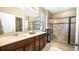 This modern bathroom features double sinks, sleek vanity, a glass-enclosed shower, and tiled floors at 26747 White Plains Way, Leesburg, FL 34748