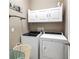 Functional laundry room with washer, dryer, white cabinetry, and ample space at 26747 White Plains Way, Leesburg, FL 34748