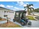 Driveway shot of golf cart parked in front of home with address number and garage at 273 Pomaria Pl, The Villages, FL 32162