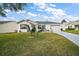 Charming single-story home featuring a well-manicured lawn, a two-car garage, and delightful curb appeal at 273 Pomaria Pl, The Villages, FL 32162