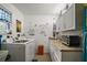 Well-lit laundry room featuring appliances, counter space, and white cabinetry at 273 Pomaria Pl, The Villages, FL 32162