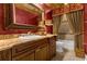 An ornate bathroom featuring a carved vanity, large framed mirror, and decorative curtains at 27852 Lake Jem Rd, Mount Dora, FL 32757