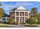 Stately brick home featuring a columned front porch and manicured landscaping at 27852 Lake Jem Rd, Mount Dora, FL 32757