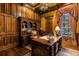 Wood-paneled home office featuring a built-in bookcase, large desk, and classic decor at 27852 Lake Jem Rd, Mount Dora, FL 32757